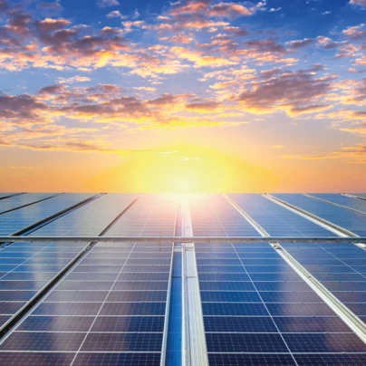 Żywy pomarańczowy słońce świeci na panelach słonecznych, wykorzystując moc światła słonecznego do wytwarzania energii słonecznej. Zaawansowana technologia wykorzystuje ciepło słońca do zrównoważonej energii.